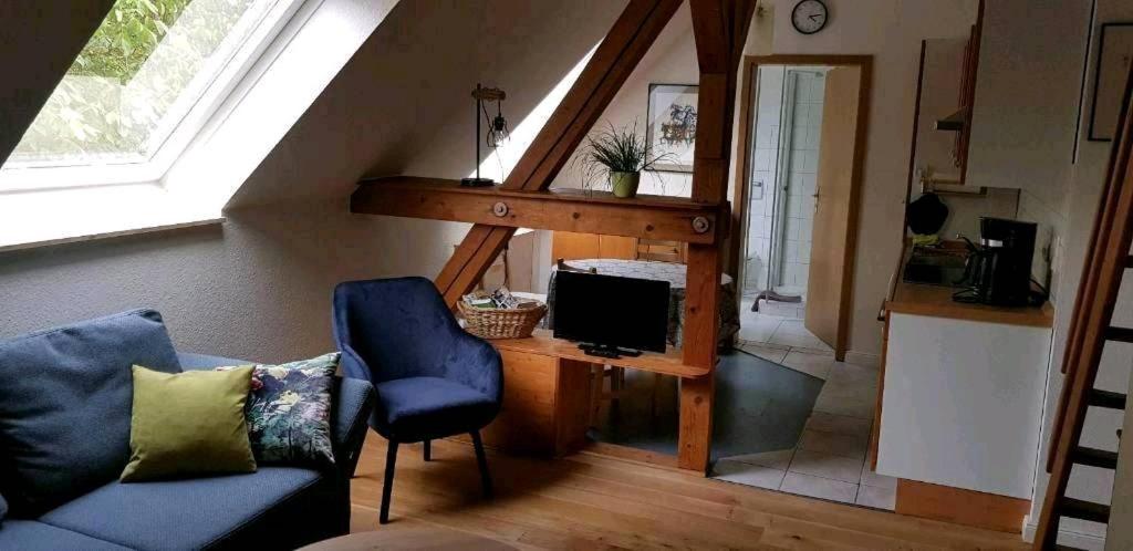 ein Wohnzimmer mit einem Sofa und einem Schreibtisch mit einem TV in der Unterkunft Ferienwohnung Helene in Gifhorn