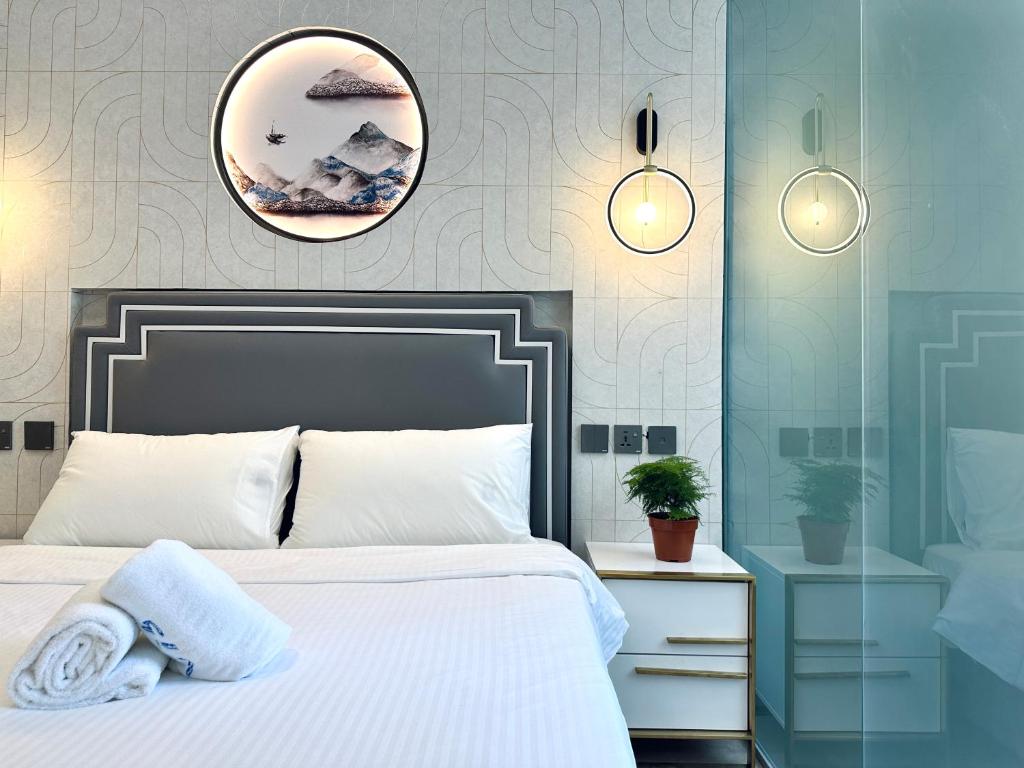 1 dormitorio con cama blanca y espejo en Kam Leng Hotel, en Singapur
