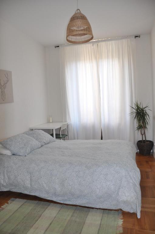 een slaapkamer met een bed en een raam met witte gordijnen bij Quevedo Suites 2 - Totalmente equipado al lado de San Marcos - Toallas, Wifi y mucho mas in León