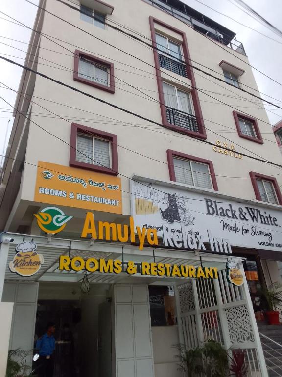 班加罗尔Hotel Amulya Relax Inn的前面有标志的建筑物