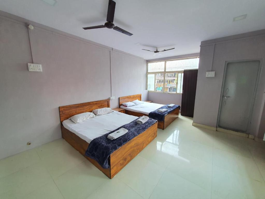 a bedroom with two beds and a ceiling fan at Hotel Family Stay in Aurangabad