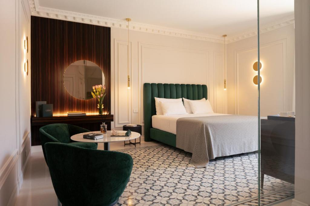 レッチェにあるパトリア パレス レッチェのベッド、テーブル、椅子が備わるホテルルームです。