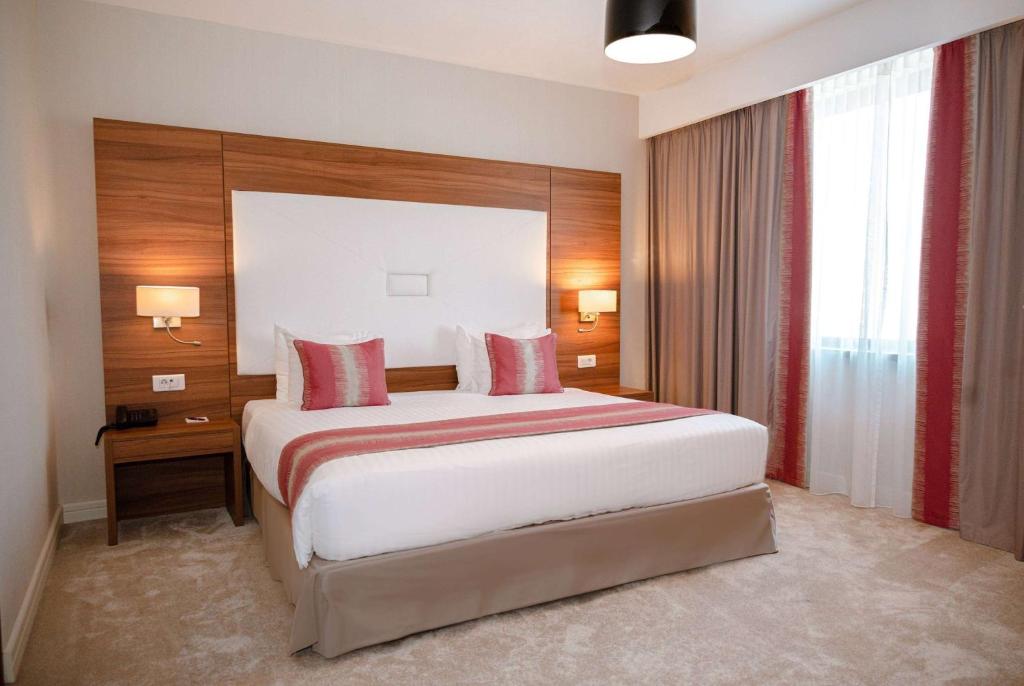 Un pat sau paturi într-o cameră la Ramada Plaza Craiova