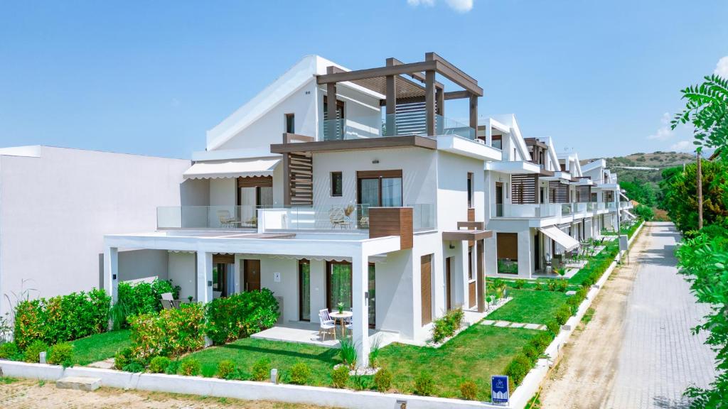 una gran casa blanca con patio en Argilos Residential Complex en Ofrínion