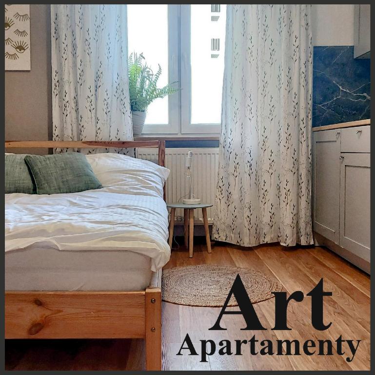 - une chambre avec un lit dans une pièce dotée d'une fenêtre dans l'établissement Art Apartamenty 1, à Kalisz