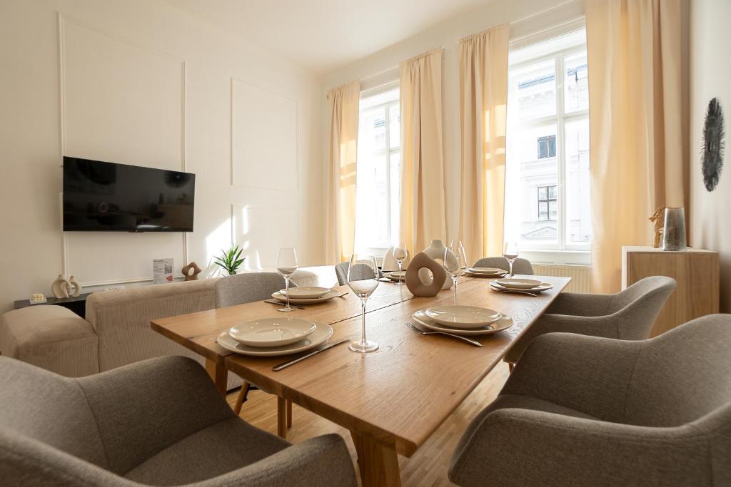 Vibrant 107 m2 flat in the city center في فيينا: غرفة طعام مع طاولة وكراسي خشبية