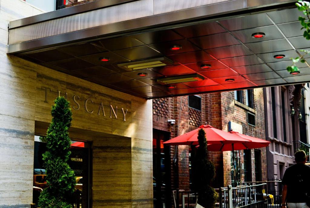 um guarda-chuva vermelho sentado fora de um restaurante em Tuscany by LuxUrban em Nova York