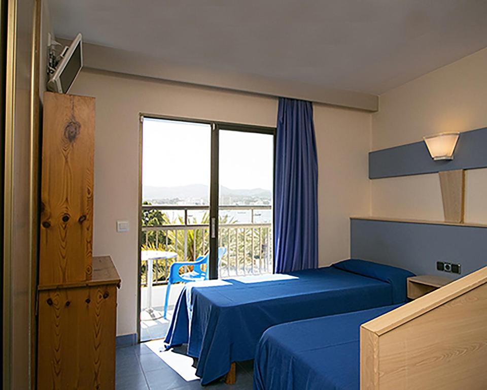 ein Hotelzimmer mit 2 Betten und einem Balkon in der Unterkunft The Blue Apartments - Adults Only in Sant Antoni de Portmany