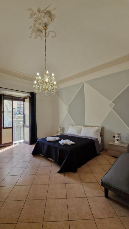 a bedroom with a bed and a chandelier at The Crazy House in Catania