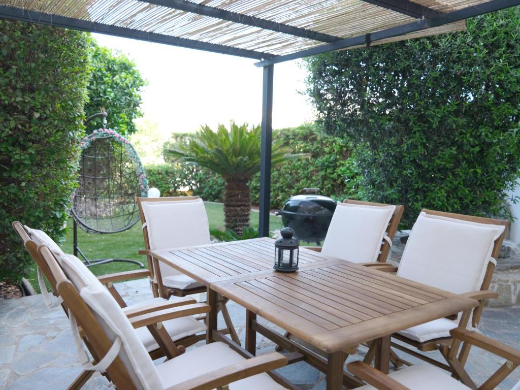 a wooden table and chairs on a patio at Orfeas Villa Porto Rafti in Porto Rafti