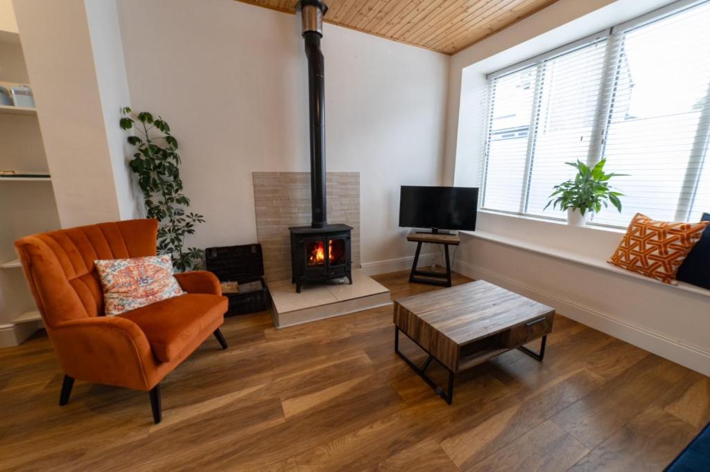 a living room with a fireplace and a chair at 4 Connaught Street Birr in Birr