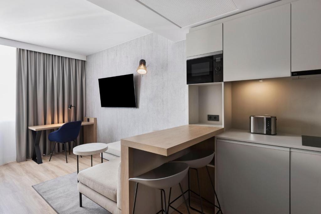 uma cozinha e sala de estar com mesa e cadeiras em Residence Inn by Marriott Vienna City East em Viena