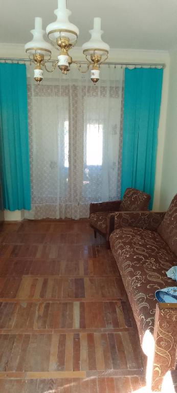 茨卡爾圖博的住宿－Sergo's Appartment，带沙发和蓝色窗帘的客厅