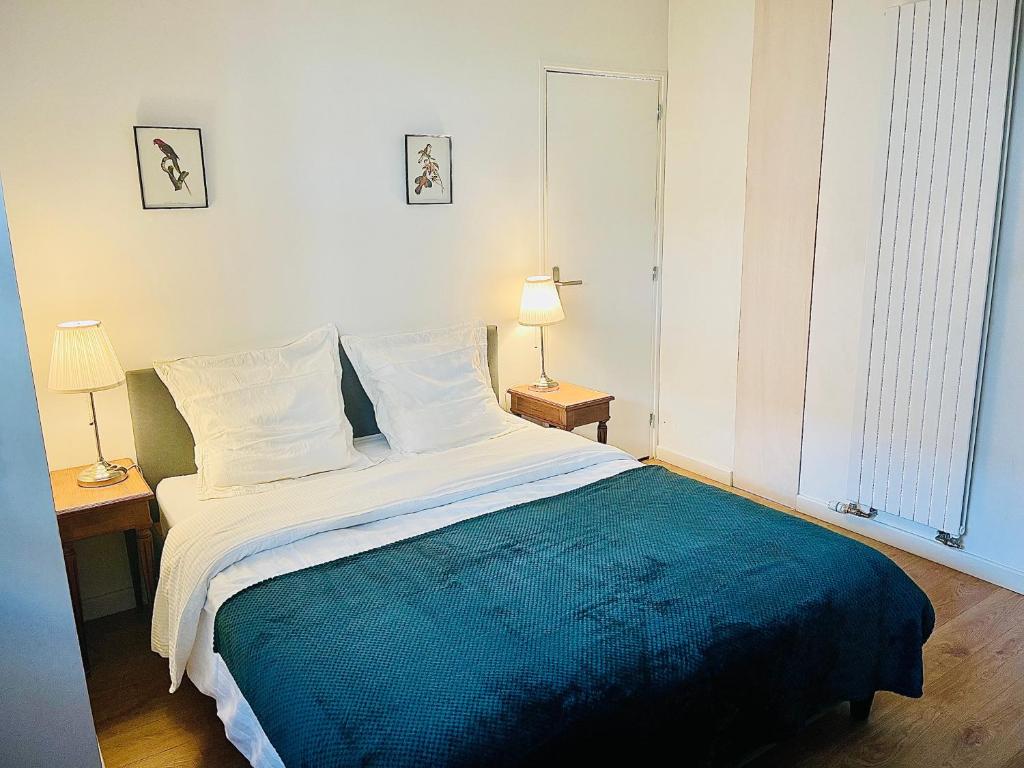 a bedroom with a large bed with a blue blanket at Maison à 5 minutes de Paris et idéal Disneyland in Montreuil