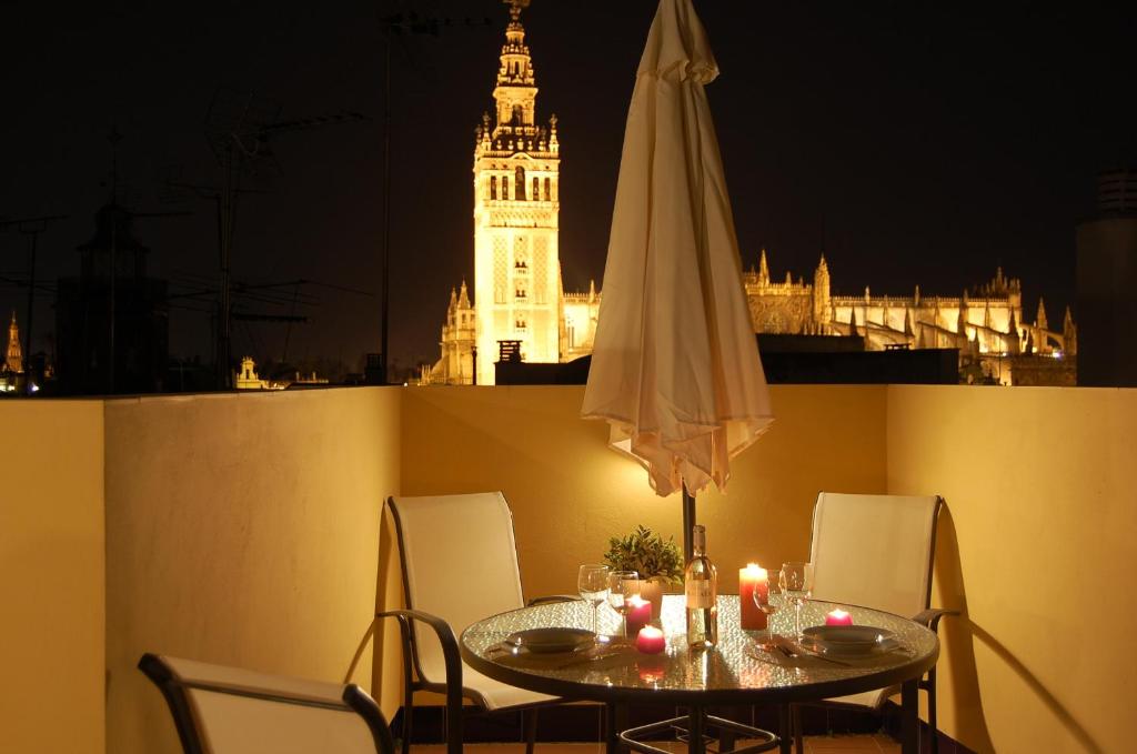 una mesa con sombrilla y una mesa con velas en Green-Apartments Giralda Views, en Sevilla