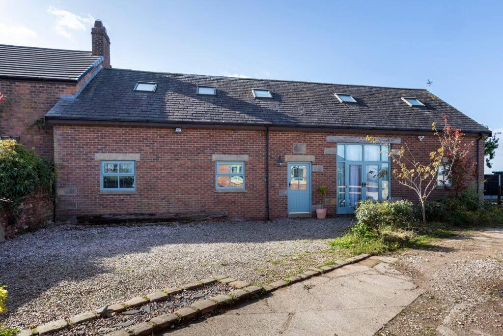 una casa in mattoni rossi con una porta blu di Large converted barn in peaceful, rural location a Hambleton