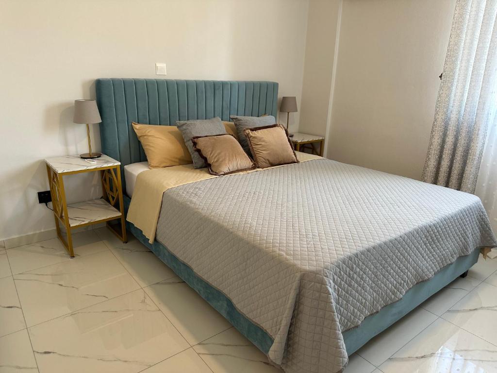Bett mit blauem Kopfteil in einem Schlafzimmer in der Unterkunft Sea view apartment near the beach in Paphos City