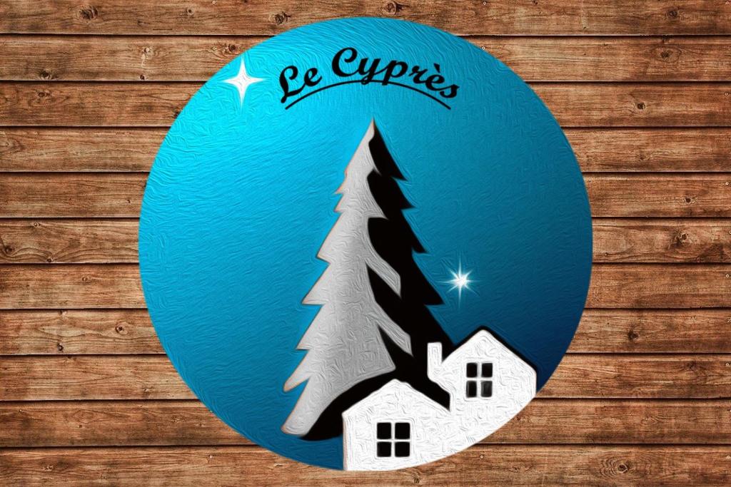 a blue sign with a house and a christmas tree at Le Cyprès en centre ville Bourg-Saint-Maurice in Bourg-Saint-Maurice