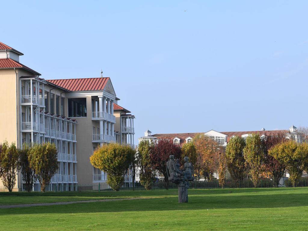 a tree in a field in front of a building at Morada Strandhotel Ostseebad Kühlungsborn in Kühlungsborn