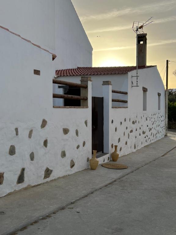 un bâtiment blanc avec une porte sur son côté dans l'établissement La casa de las piedras, 