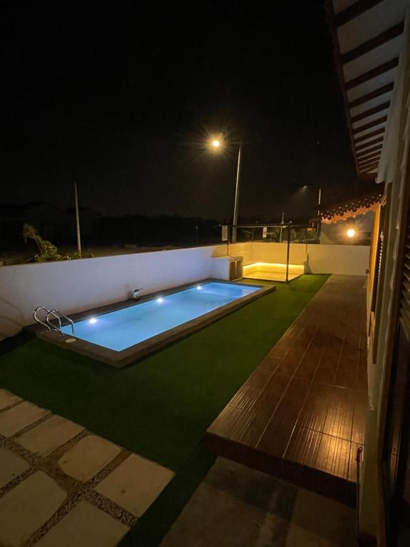a swimming pool in the middle of a yard at night at Traditional Melaka Homestay with Private Pool in Kampong Bukit Katil