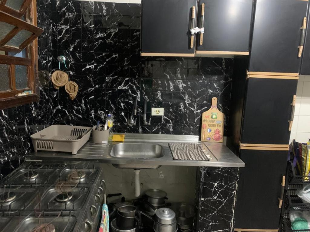 a small kitchen with a sink and a stove at Casa em Peruibe 3 dormitórios sendo 1 suite Pe na Areia in Peruíbe