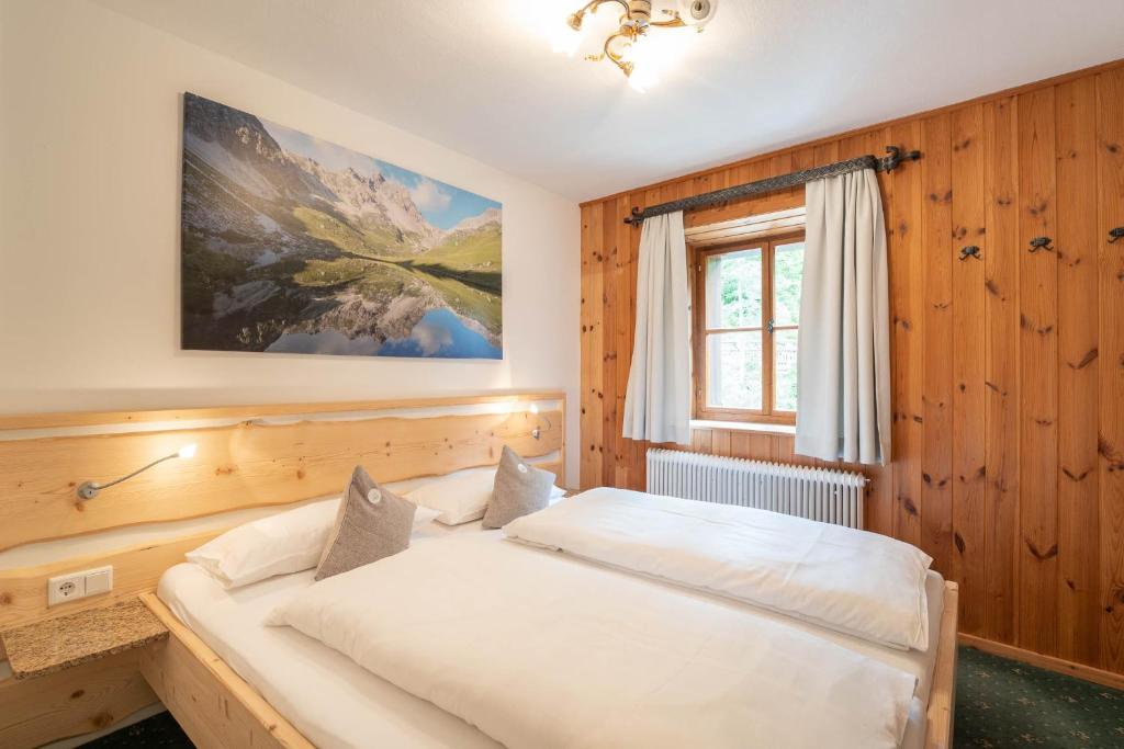 a bedroom with a large white bed in a room at Ferienhaus zur Hackenschmiede in Mauterndorf