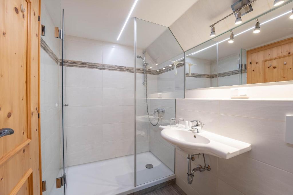 a white bathroom with a sink and a shower at Ferienhaus zur Hackenschmiede in Mauterndorf