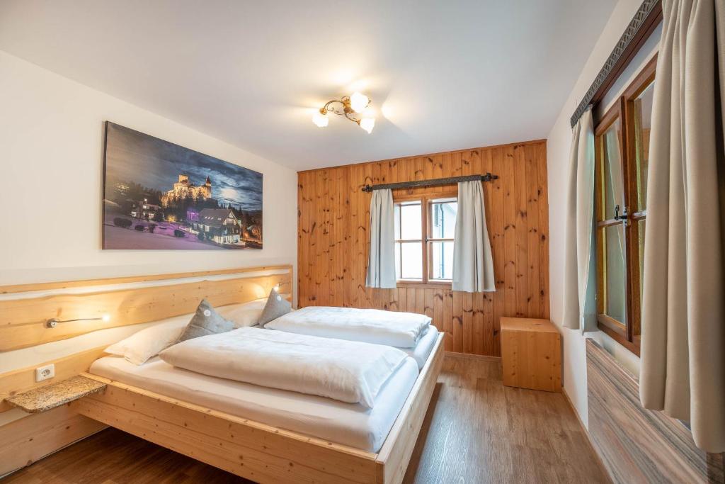 a bedroom with a bed in a wooden wall at Ferienhaus zur Hackenschmiede in Mauterndorf