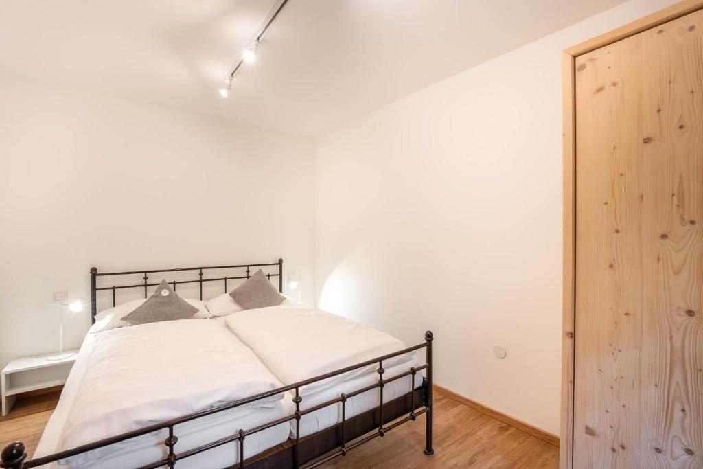 a bedroom with a bed and a white wall at Ferienhaus zur Hackenschmiede in Mauterndorf