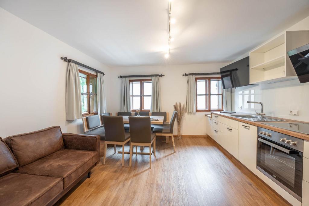 eine Küche und ein Wohnzimmer mit einem Sofa und einem Tisch in der Unterkunft Ferienhaus zur Hackenschmiede in Mauterndorf