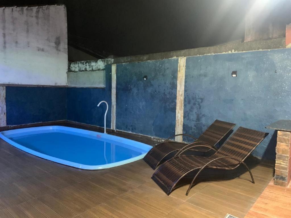 eine große blaue Badewanne in einem Zimmer mit 2 Stühlen in der Unterkunft Casa em Peruibe 3 dormitórios sendo 1 suite in Peruíbe