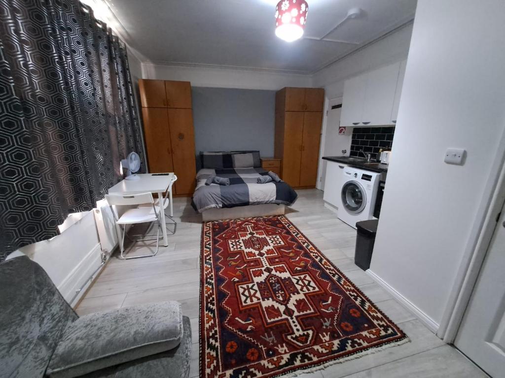 uma sala de estar com uma cama e um tapete em Private Studio on Finchley Road em Londres
