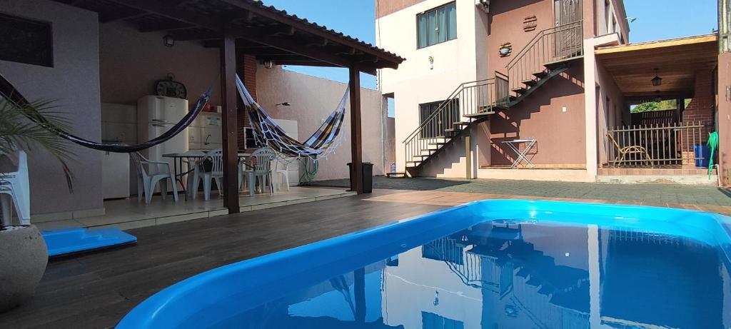 a blue swimming pool in front of a building at Catuai in Foz do Iguaçu