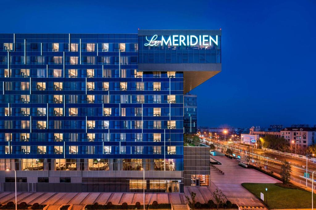 a large building with a sign on the side of it at Le Meridien Shanghai Hongqiao,Minhang in Shanghai