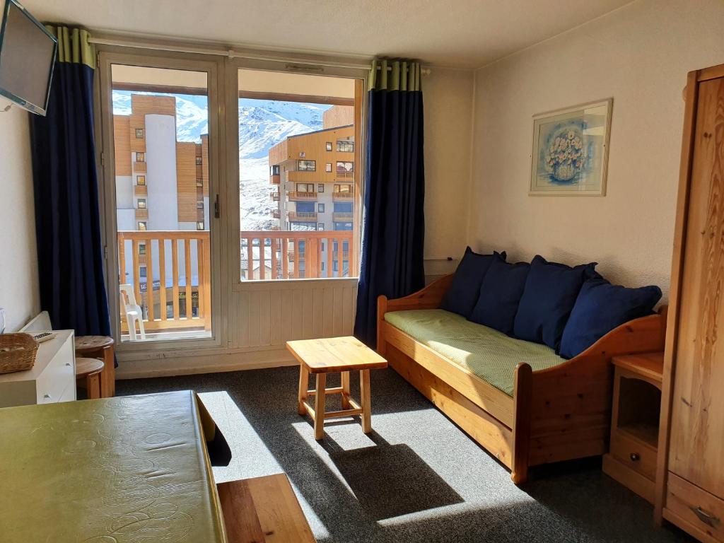 een woonkamer met een bank en een raam bij 34 Roche Blanche in Val Thorens