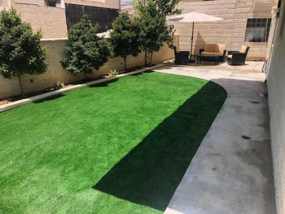 un césped con césped verde en un patio en Tze'elam gardens super special NO Airbnb FEE's WOW, en Zanoaẖ