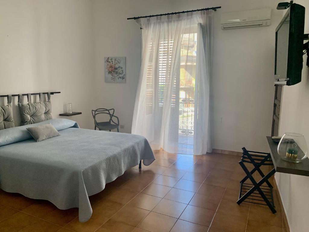 a bedroom with a bed and a television and a window at Isola delle Femmine Apartment in Capaci in Capaci