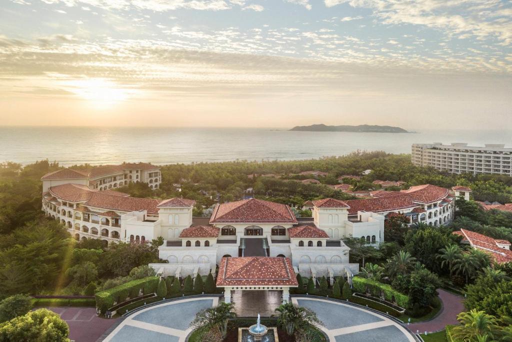 三亚JW Marriott Sanya Haitang Bay Resort & Spa的度假村的鸟瞰图，背景是大海