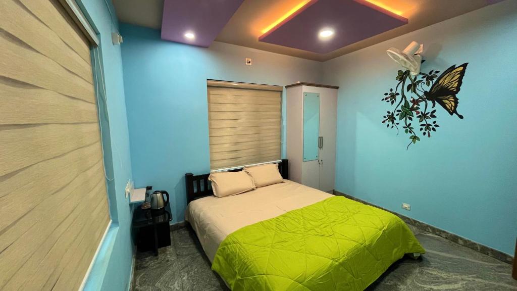 1 dormitorio con 1 cama con una mariposa en la pared en Welldone Wayanad Holidays en Sultans Battery