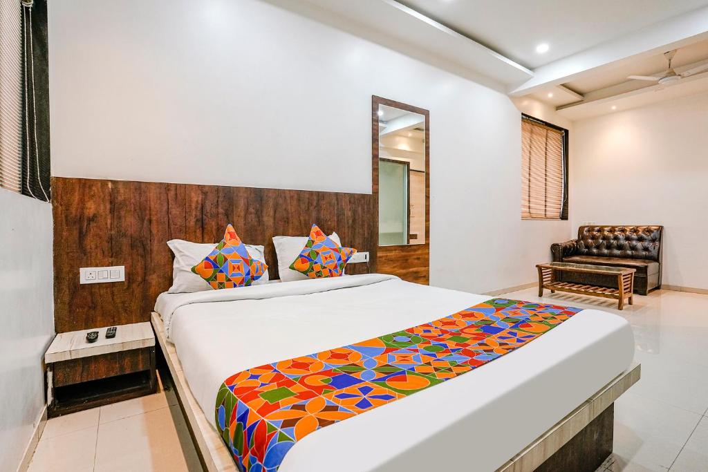 a bedroom with a large bed and a chair at FabHotel Krishna Inn in Bhiwandi