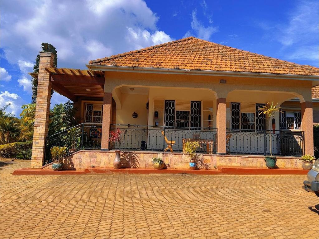 a house with a brick driveway in front of it at Airport Link Guest House in Entebbe