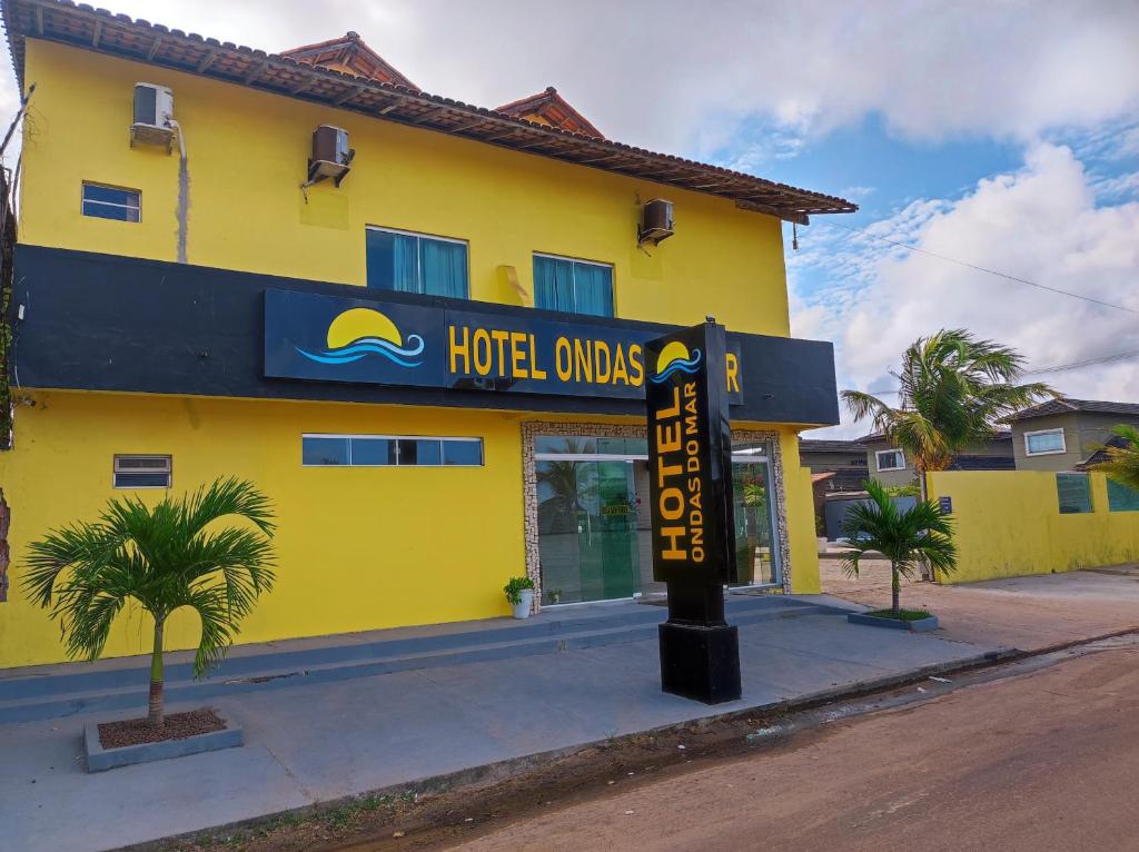 a hotel oasis sign in front of a yellow building at Hotel Ondas do Mar in Salinópolis