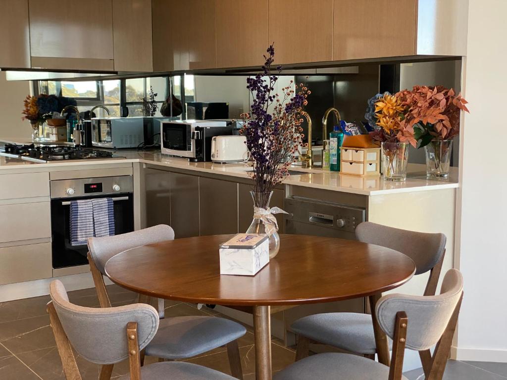 a kitchen with a wooden table with chairs and a table sidx sidx sidx at Serene Parkside Retreat 2Brs@ close 2 Olympic park in Sydney