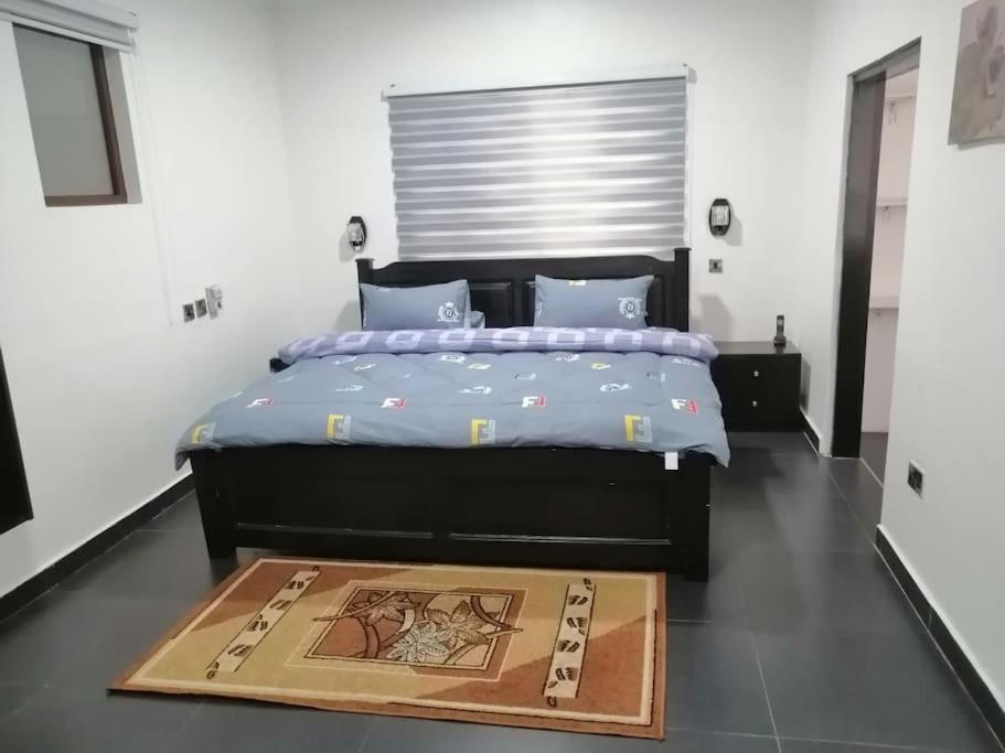 a bedroom with a large bed with a wooden mat on the floor at furnished 4 bd hse with pool in Accra