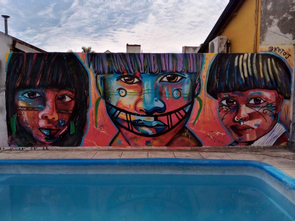 a painting of three women on a wall at Parivaar Host in Concepción del Uruguay