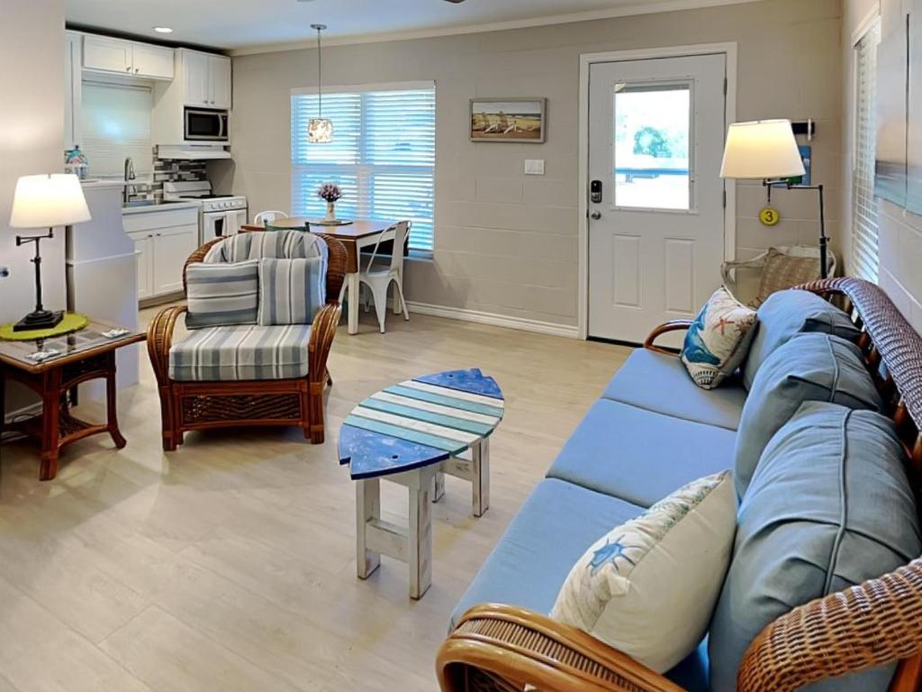 a living room with a blue couch and a kitchen at Harbor Lights Cottages 3 in Rockport