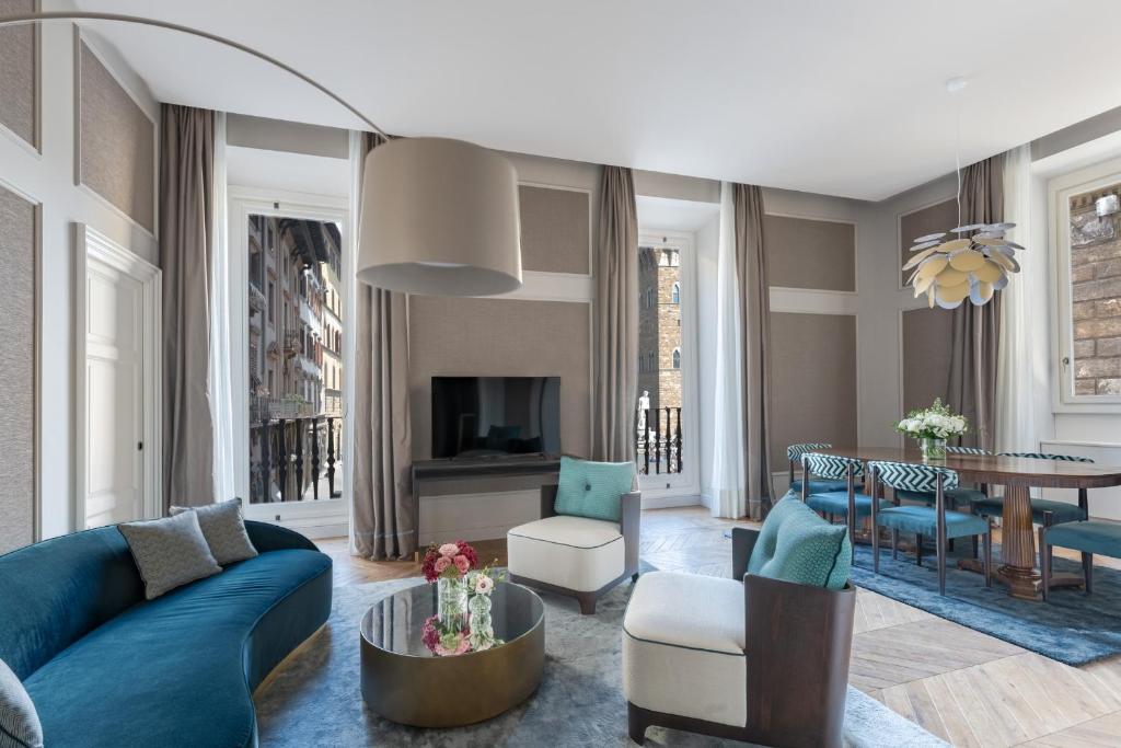 a living room with a blue couch and a table at Apartments Florence - Palazzo Signoria luxury Apartments 1-Biancone in Florence