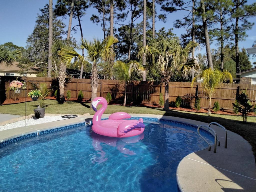 a pink inflatable flamingo in a swimming pool at Very Private 3 Bed Home with HEATED Pool Palms and Big Fenced Yard in Pensacola