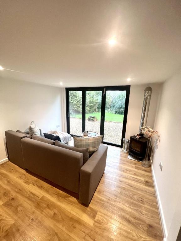 a living room with a couch and wooden floors at The Cranny at Valley farm in Bicester
